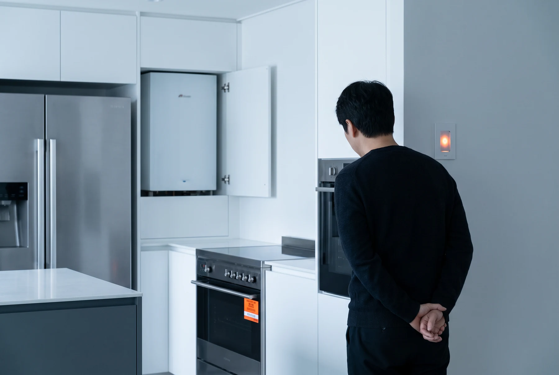 Person observing appliances in a clean modern kitchen