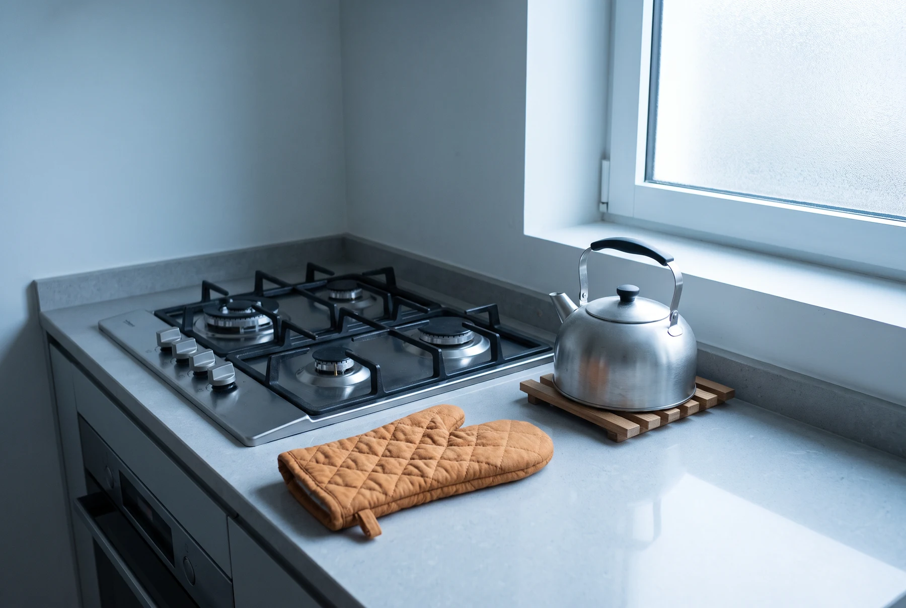 Unlit gas cooker and kettle on a counter