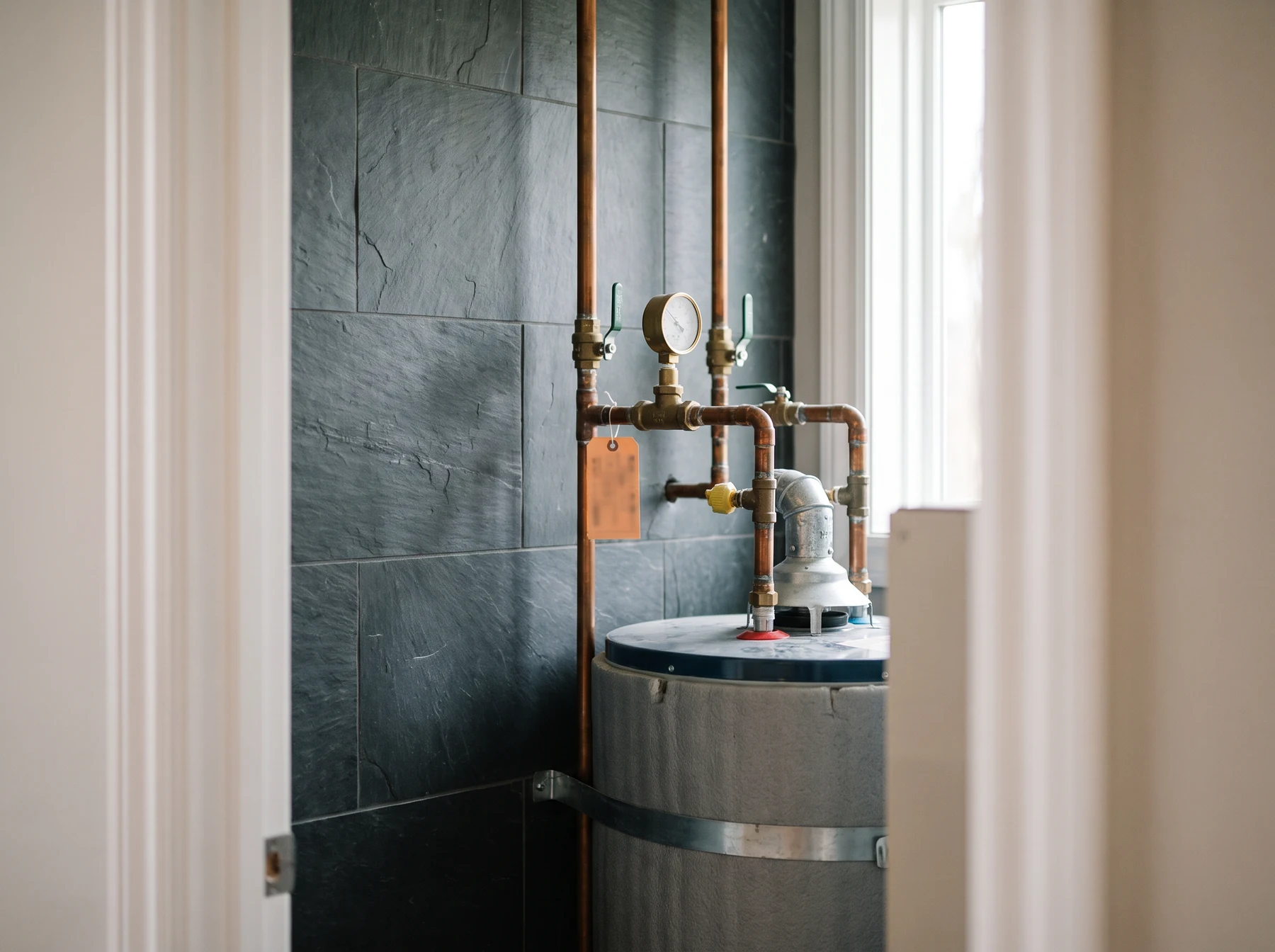 Water heater system and pipes on tiled wall